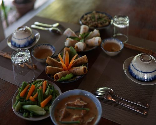 A beautifully set Thai family dinner table with various homemade dishes